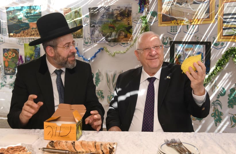 President Reuven Rivlin admires the etrog of Ashkenazi Chief Rabbi David Lau (photo credit: MARK NEIMAN - GPO)