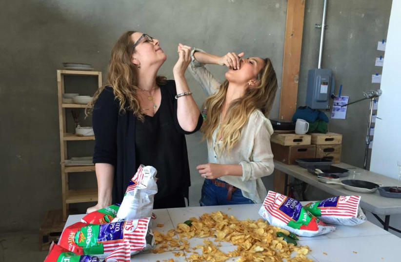 ADEENA SUSSMAN (left) and Chrissy Teigen sample potato chips while working on creating recipes. (photo credit: AUBRIE PICK)