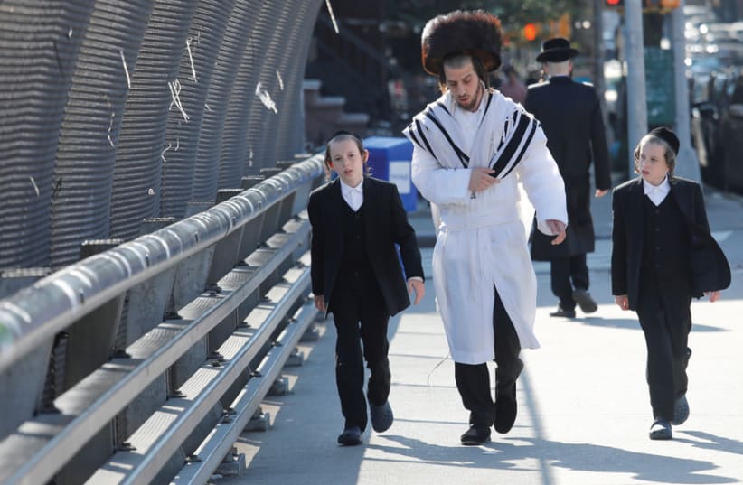 A JEWISH FAMILY walks in Williamsburg, Brooklyn, on Yom Kippur. (photo credit: SHANNON STAPLETON / REUTERS)