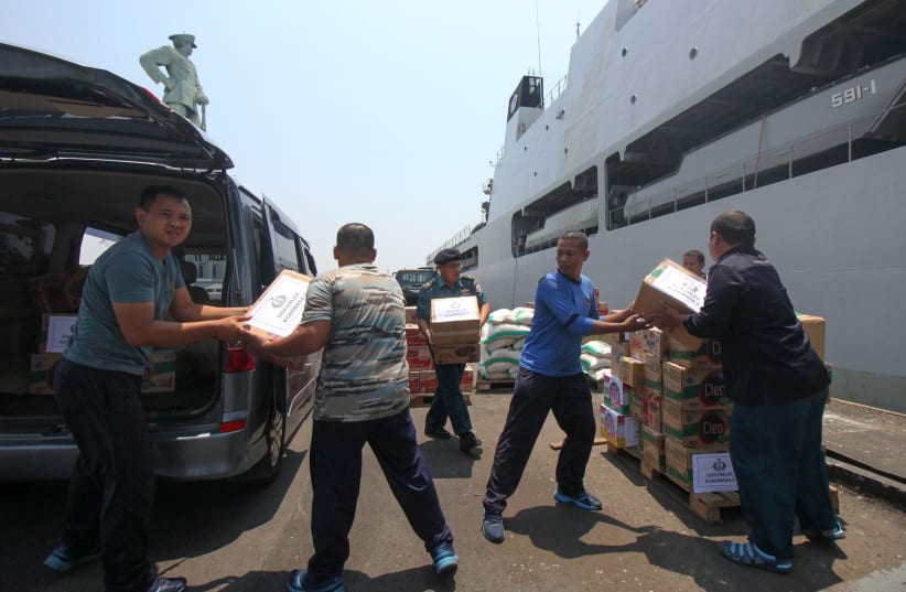 Indonesian navy prepare packages of aid to distribute to victims of the earthquake and tsunami in Palu at Koarmada II port in Surabaya, East Java, Indonesia (photo credit: ANTARA FOTO/DIDIK SUHARTONO/VIA REUTERS)