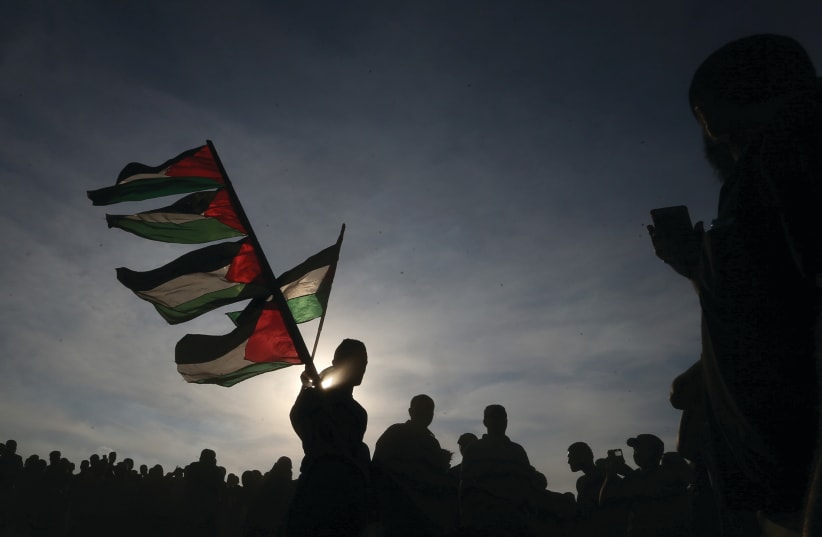 Palestinian protesters wave flag at recent events (photo credit: REUTERS)