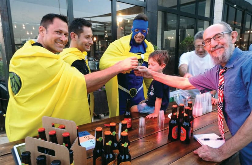 THE WRITER (right) raises a glass with ‘superheroes’ from Six Pack Brewing, at a recent craft beer festival. (photo credit: MIKE HORTON)