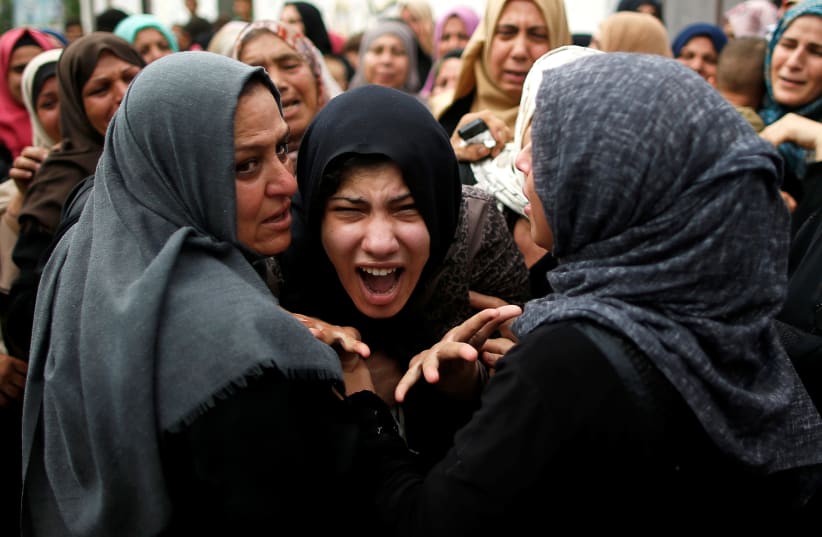 A relative of Palestinian gunman Naji al-Zaneen, who was killed in an Israeli air strike, reacts during his funeral in the northern Gaza Strip October 17, 2018 (photo credit: SUHAIB SALEM / REUTERS)