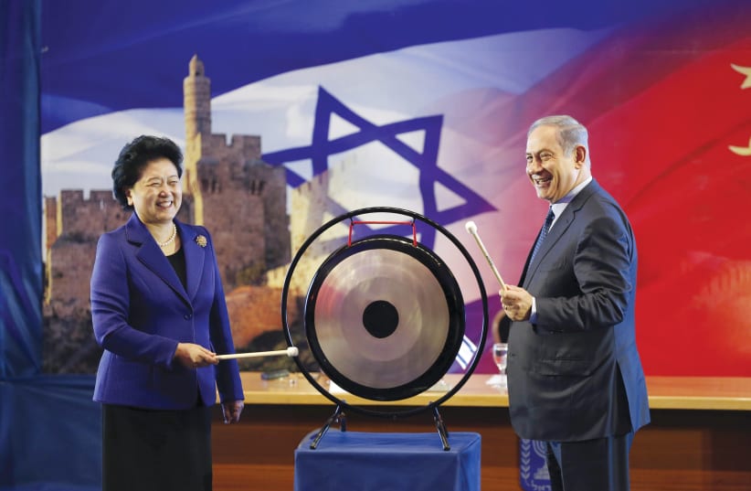 PRIME MINISTER BENJAMIN NETANYAHU and Chinese Vice Premier Liu Yandong strike a gong during the second JCIC meeting in March 2016 (photo credit: REUTERS)
