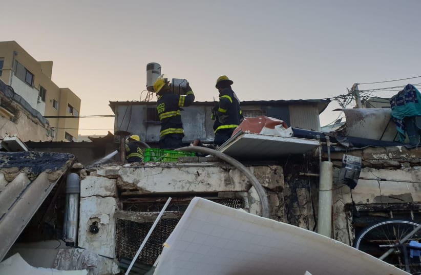 Firefighters at the burnt home of a 62-year-old woman killed in a fire in Tel Aviv's Carmel Market on Monday morning, October, 22, 2018 (photo credit: ISRAEL FIRE AND RESUCE SERVICES)