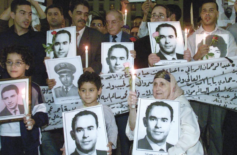 MOROCCANS HOLD portraits of former Moroccan opposition leader Mahdi Bin Barka during a candle-lit gathering in Rabat in 2002. (photo credit: REUTERS)