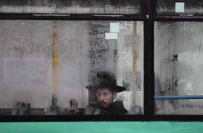 An ultra-Orthodox Jewish man looks out from a condensation-covered window of a bus in Jerusalem December 11, 2013 (photo credit: REUTERS/AMMAR AWAD)