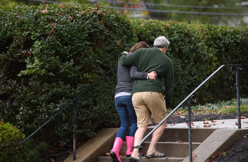 Neighbors around the corner from the site of a mass shooting at the Tree of Life Synagogue embrace one another in the Squirrel Hill neighborhood on October 27, 2018 in Pittsburgh, Pennsylvania (photo credit: JEFF SWENSEN / GETTY IMAGES NORTH AMERICA / AFP)