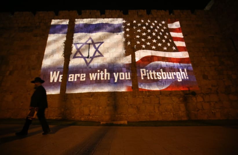 An Israeli and an American flag are projected onto Jerusalem's Old City walls near Jaffa Gate in solidarity with the victims of the shooting attack in Pittsburgh (photo credit: MARC ISRAEL SELLEM/THE JERUSALEM POST)