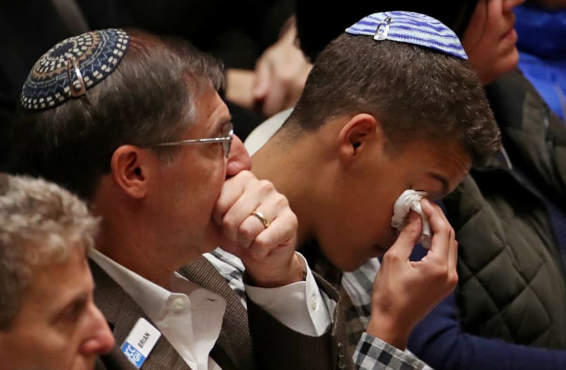 Mourners react during a memorial service at the Sailors and Soldiers Memorial Hall of the University of Pittsburgh, a day after 11 worshippers were shot dead at a Jewish synagogue in Pittsburgh, Pennsylvania, October 28, 2018 (photo credit: CATHAL MCNAUGHTON/REUTERS)