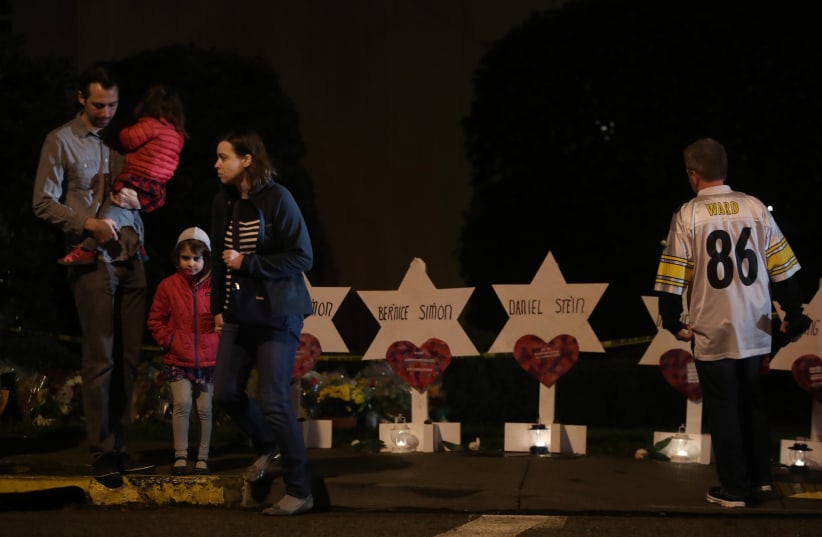 Mourners visit a makeshift memorial outside the Tree of Life synagogue, a day after 11 Jewish worshippers were shot dead in Pittsburgh, Pennsylvania, October 28, 2018 (photo credit: CATHAL MCNAUGHTON/REUTERS)