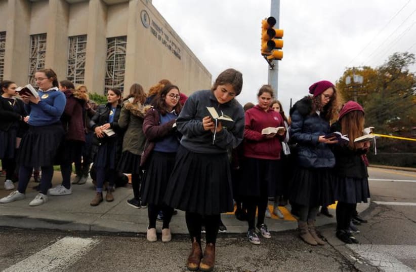 Pupils from the Yeshiva Girls School pray outside the Tree of Life synagogue following Saturday's shooting at the synagogue in Pittsburgh, Pennsylvania, U.S., October 29, 2018 (photo credit: CATHAL MCNAUGHTON/REUTERS)