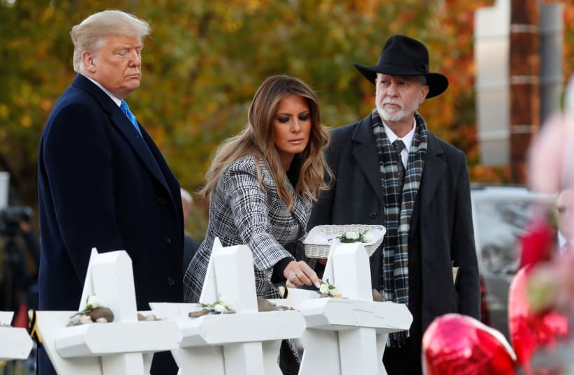   U.S. President Donald Trump and first lady Melania Trump stand with Rabbi Jeffrey Myers as they place stones at a makeshift memorial outside the Tree of Life synagogue in the wake of the shooting at the synagogue where 11 people were killed and six people were wounded in Pittsburgh, Pennsylvania,  (photo credit: KEVIN LAMARQUE/REUTERS)