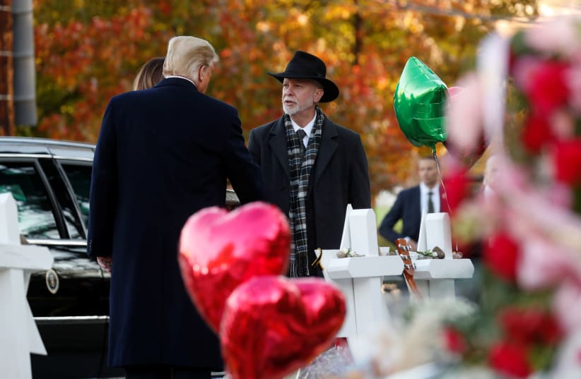 U.S. President Donald Trump talks with Tree of Life Synagogue Rabbi Jeffrey Myers as they stand at a makeshift memorial to the victims outside the synagogue where a gunman killed eleven people and wounded six during a mass shooting in Pittsburgh, Pennsylvania, U.S., October 30, 2018.  (photo credit: KEVIN LAMARQUE/REUTERS)