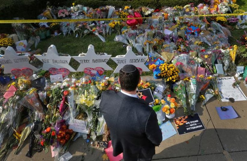 A man prays at a makeshift memorial outside the Tree of Life synagogue following Saturday's shooting at the synagogue in Pittsburgh, Pennsylvania, U.S., October 31, 2018 (photo credit: CATHAL MCNAUGHTON/REUTERS)