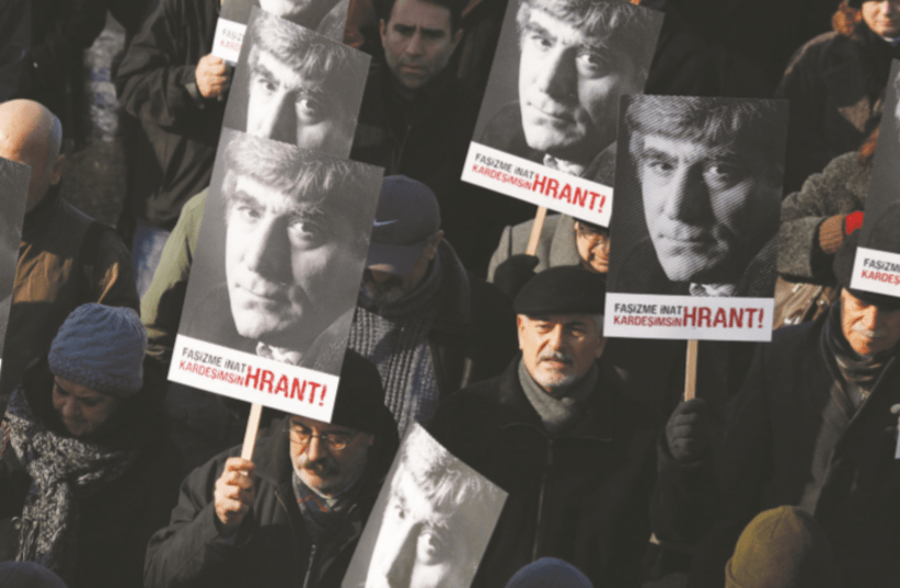FRIENDS OF slain Turkish-Armenian journalist Hrant Dink march with posters bearing the image of Dink during a demonstration near a courthouse in Istanbul in 2012 (photo credit: MURAD SEZER/REUTERS)