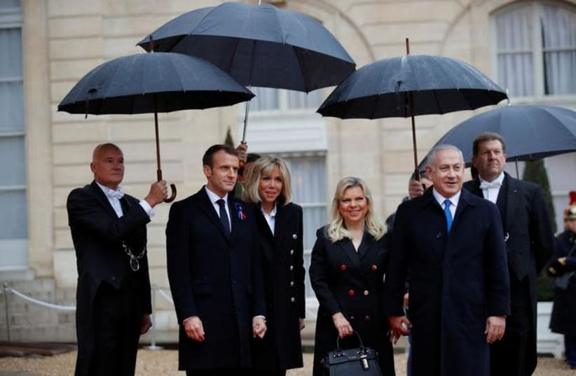 French President Emmanuel Macron and his wife Brigitte Macron welcome Israel Prime Minister Benjamin Netanyahu and his wife Sara at the Elysee Palace as part of the commemoration ceremony for Armistice Day, 100 years after the end of the First World War, in Paris, France, November 11, 2018 (photo credit: REUTERS/PHILIPPE WOJAZER)