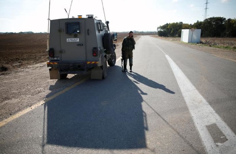 An IDF soldier stands next to an armored vehicle in Kibbutz Nahal Oz, near the Gaza Strip border, Israel November 12, 2018 (photo credit: AMIR COHEN/REUTERS)