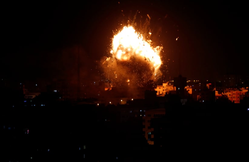 An explosion is seen during an Israeli air strike on Hamas's television station, in Gaza City November 12, 2018 (photo credit: REUTERS/AHMED ZAKOT)
