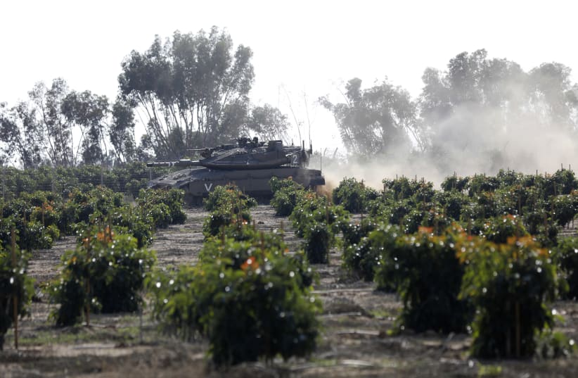 An IDF tank rolls along the Israeli border with the Gaza Strip on November 13 2018 (photo credit: MENAHEM KAHANA / AFP)