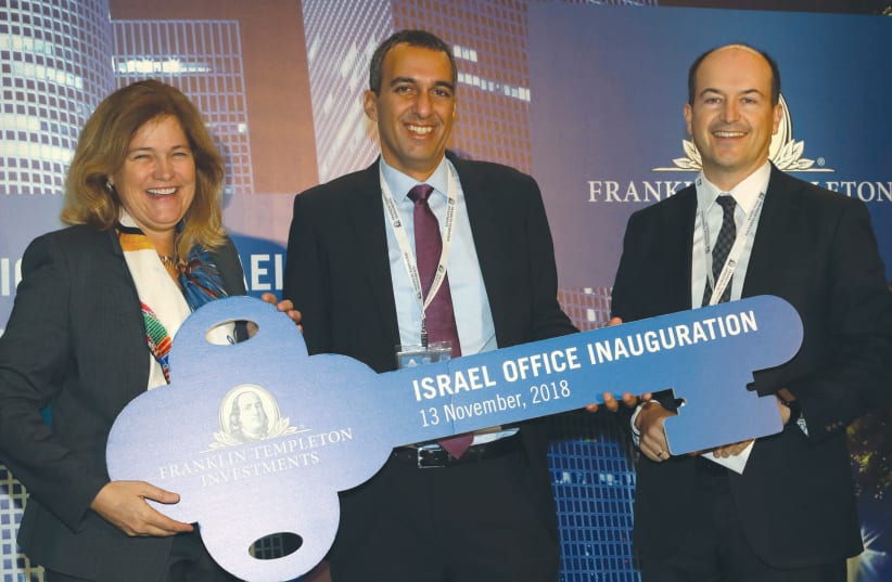 PRESIDENT and COO of Franklin Templeton Investments Jenny Johnson awards Uzi Yitzhak, head of Franklin Templeton, Israel, the key for its new venues in Herzliya. (photo credit: SIVAN FARAG)