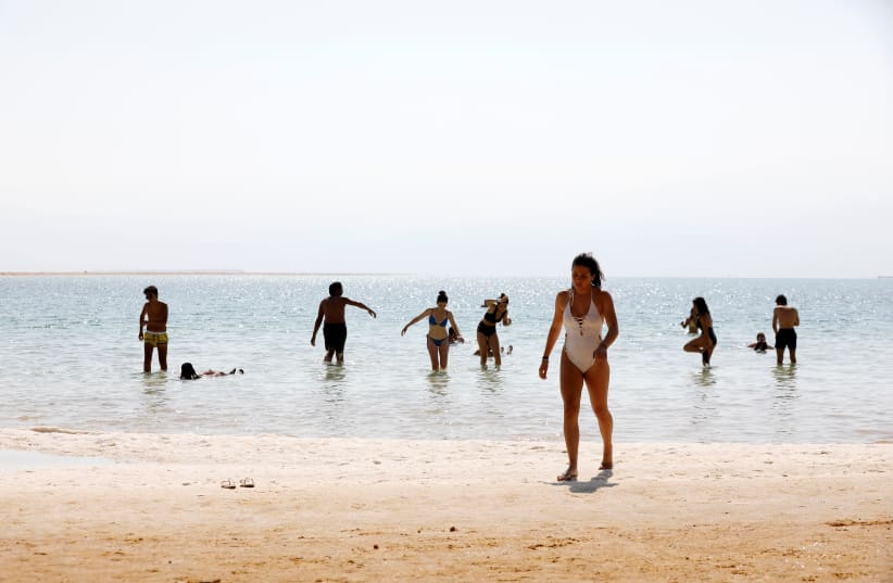 Tourists bathe at the shore of the Dead Sea, Israel July 17, 2018. Picture taken July 17, 2018. (photo credit: AMIR COHEN/REUTERS)