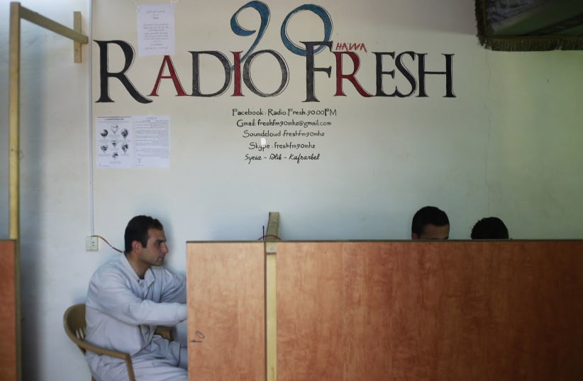 Activists sit at the premises of the Radio Fresh station in Kafranbel town in the Idlib governorate (photo credit: REUTERS/HAMID KHATIB)