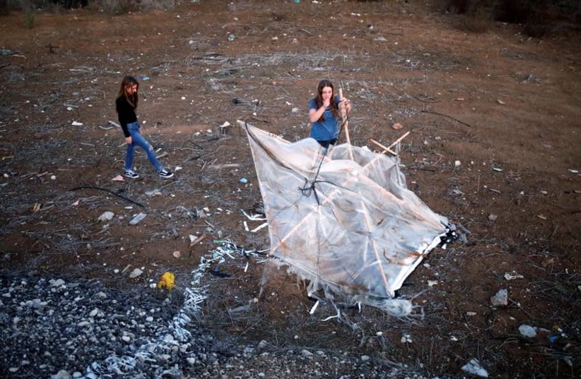Israeli teens, Meshy Elmkies (R), 16, and Lee Cohen, 17, co-managers of Instagram account, Otef.Gaza, show Reuters journalists an incendiary kite launched from the Gaza Strip, during an interview in Kibbutz Kerem Shalom which borders the Gaza Strip, in southern Israel November 11, 2018 (photo credit: AMIR COHEN/REUTERS)