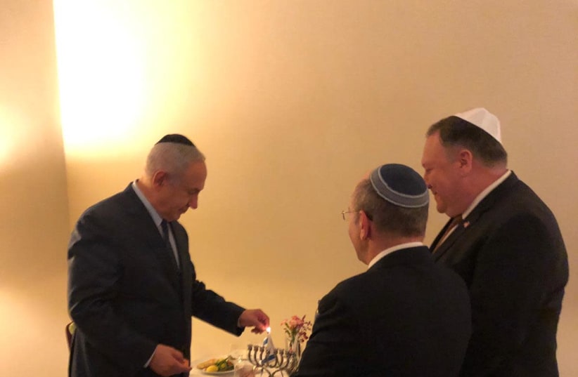 Prime Minister Benjamin Netanyahu (L), U.S. Secretary of State Mike Pomeo (R), and National Security Council head Meir Ben-Shabbat (C) light Hanukkah candles during a meeting in Brussles, December 3, 2018 (photo credit: GPO)