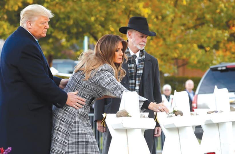 US President Donald Trump and First Lady Melania Trump place stones on a memorial to the 11 shooting victims as they stand with Rabbi Jeffrey Myers outside the Tree of Life Synagogue in Pittsburgh, on October 30 (photo credit: KEVIN LAMARQUE/REUTERS)