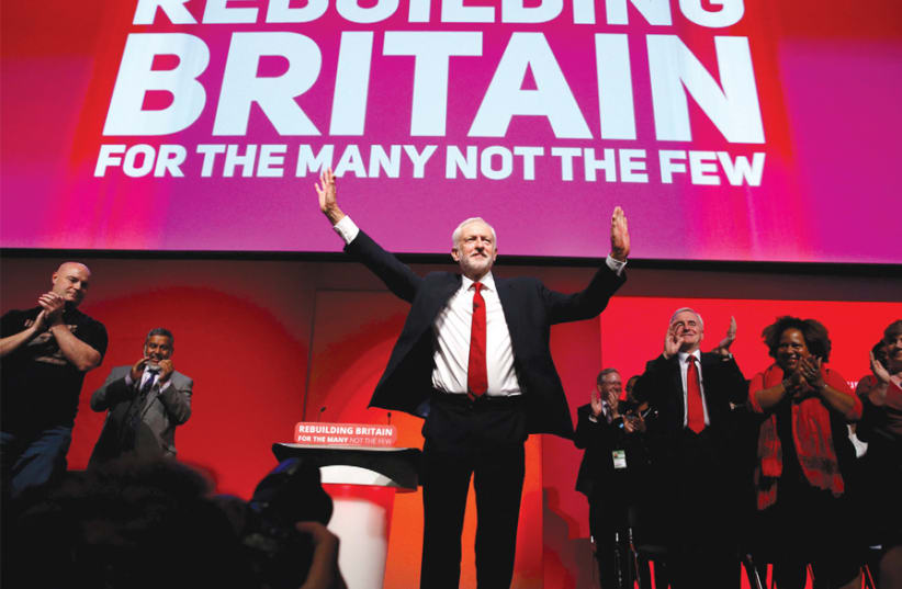 Jeremy Corbyn acknowledges an audience’s applause (photo credit: PHIL NOBLE/REUTERS)