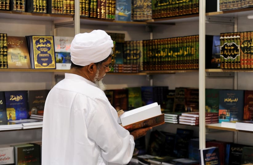 A handout picture released by the Qatari ministry of culture shows a man browsing through a book at the Doha International Book Fair in the Qatari capital on November 25, 2010 (photo credit: AFP PHOTO/HO)