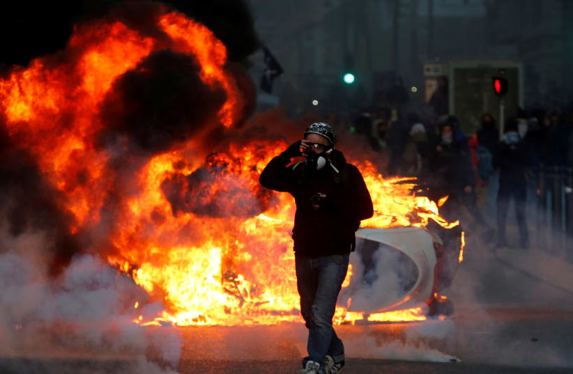 A car burns during clashes with police at a demonstration of the "yellow vests" movement in Marseille, France, December 8, 2018 (photo credit: JEAN-PAUL PELISSIER / REUTERS)