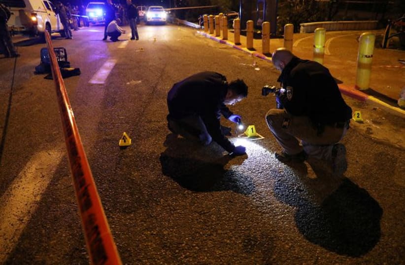 Israeli security forces and emergency personnel work at the scene of shooting attack, near the Israeli settlement of Ofra, December 9, 2018 (photo credit: AMMAR AWAD / REUTERS)
