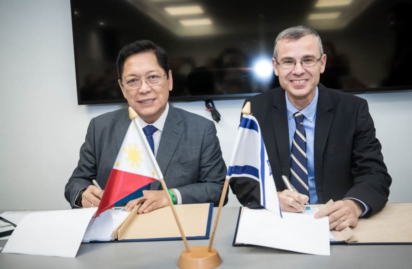 Minister of Tourism Yariv Levin (R) and Philippines Labor and Employment Minister Silvestre Bello sign a bilateral labor agreement, December 11, 2018  (photo credit: ODED KARNI)