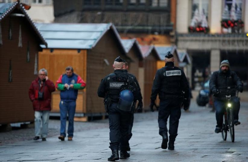 French Gendarmes patrol past wooden barracks shops at the traditional Christkindelsmaerik (Christ Child market) closed the day after a shooting in Strasbourg, France, December 12, 2018. (photo credit: VINCENT KESSLER/ REUTERS)