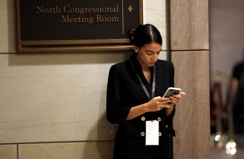 Alexandria Ocasio-Cortez waits for a House of Representatives member-elect welcome briefing on Capitol Hill in Washington, U.S., November 15, 2018 (photo credit: YURI GRIPAS/REUTERS)