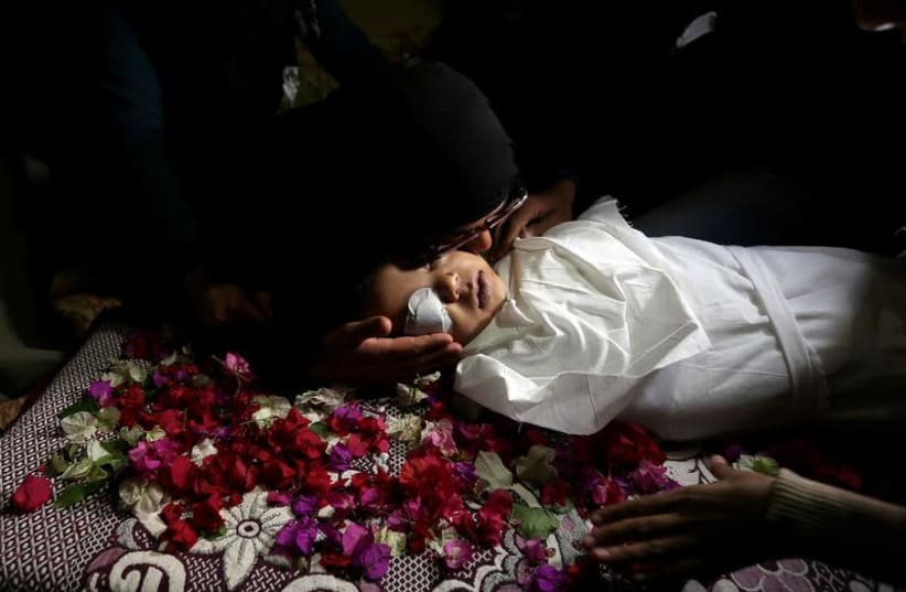  VISUAL COVERAGE OF SCENES OF INJURY OR DEATH A relative kisses the body of Palestinian boy Ahmed Abed during his funeral in Khan Younis in the southern Gaza Strip December 12, 2018.  (photo credit: REUTERS/IBRAHEEM ABU MUSTAFA)