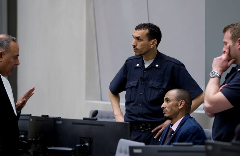 Alleged jihadist leader Al Hassan Ag Abdoul Aziz Ag Mohamed Ag Mahmoud (2ndR), listens to his duty counsel Yasser Hassan (L), prior to his initial appearance on charges of war crimes and crimes against humanity at the International Criminal Court in The Hague, The Netherlands April 4, 2018 (photo credit: PETER DEJONG/REUTERS)