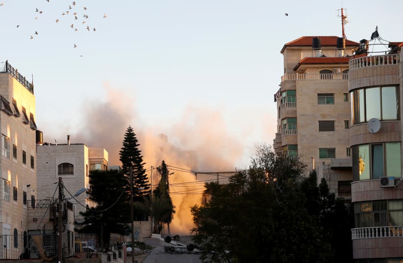 Smoke rises as Israeli forces blow up the house of Palestinian family Abu Humaid, in Ramallah, in the Israeli-occupied West Bank December 15, 2018 (photo credit: MOHAMAD TOROKMAN/REUTERS)