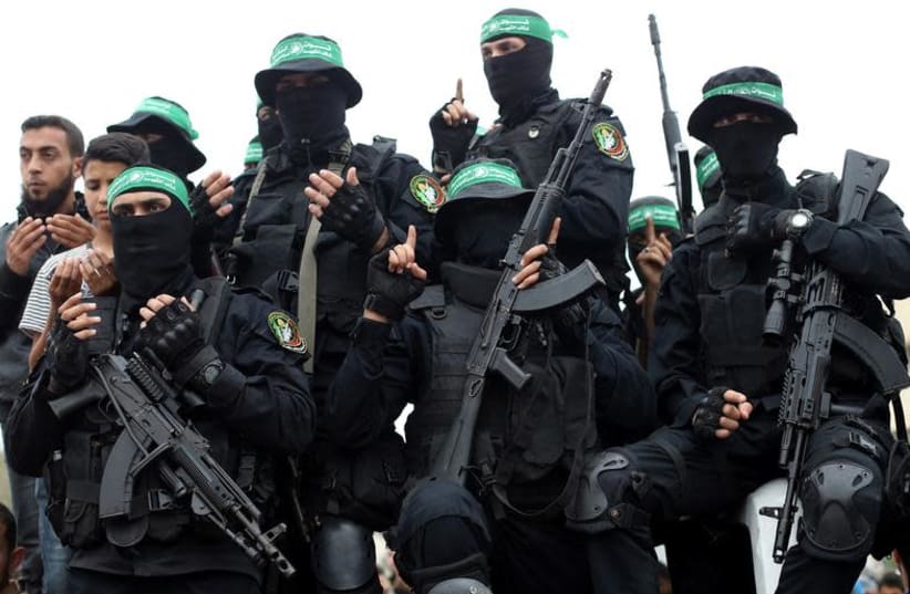 Palestinian Hamas militants attend the funeral of their comrades who were killed in an explosion, in the central Gaza Strip May 6, 2018 (photo credit: REUTERS/IBRAHEEM ABU MUSTAFA)