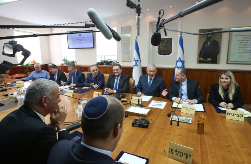 Naftali Bennett (foreground) looks on as Prime Minister Benjamin Netanyahu (C) addresses a weekly cabinet meeting, December 16th, 2018 (photo credit: MARC ISRAEL SELLEM/THE JERUSALEM POST)