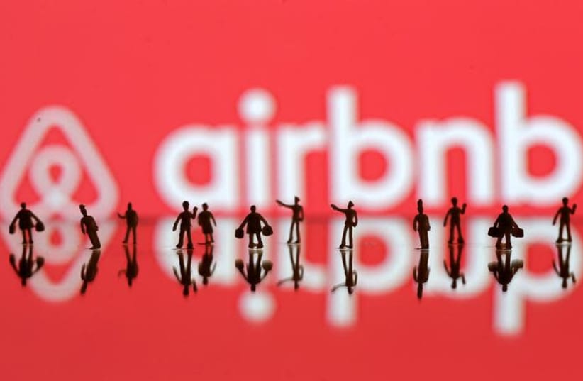 A 3D printed people's models are seen in front of a displayed Airbnb logo in this illustration taken, June 8, 2016 (photo credit: DADO RUVIC/REUTERS)