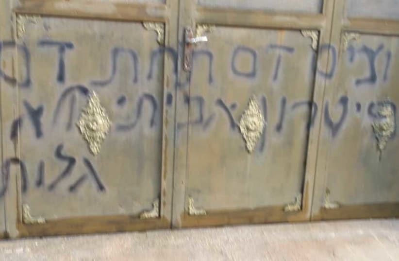 A home in the Palestinian town of Yasuf defaced, the Hebrew text is "We want [to see] blood for blood, a real solution not a Diaspora [based] solution." The Hebrew word for solution is misspelled.  (photo credit: MOHAMAD ATTINI)