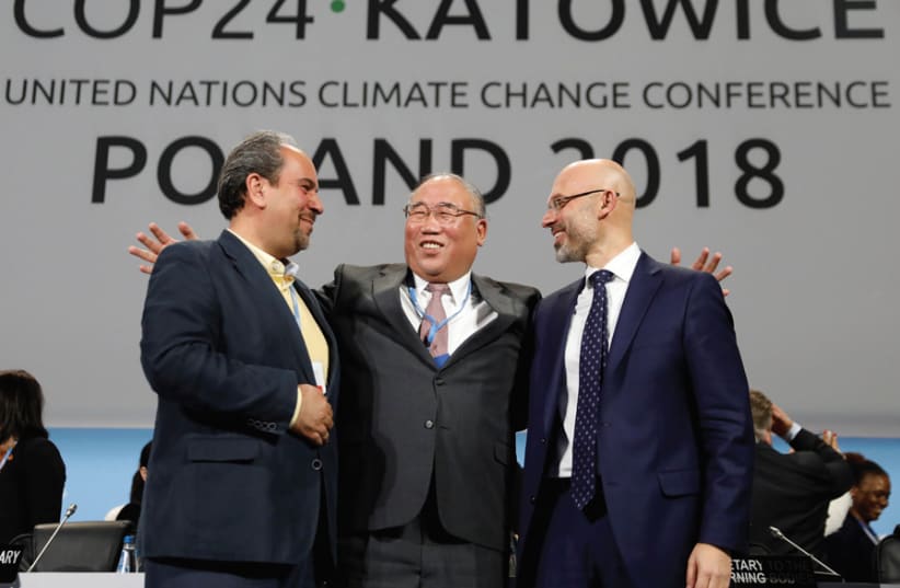 (FROM LEFT) Iran’s head of delegation Majid Shafiepour Motlagh, China’s head of delegation Xie Zhenhua and COP24 president Michal Kurtyka smile after adopting the final agreement during the COP24 UN Climate Change Conference 2018 in Katowice, Poland, on December 15. (photo credit: REUTERS)