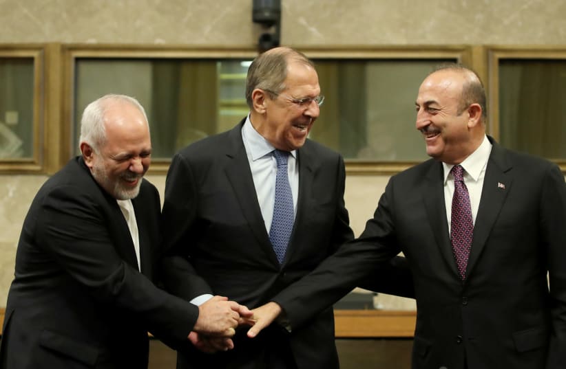 Russian Foreign Minister Sergei Lavrov, Turkish Foreign Minister Mevlut Cavusoglu and Iranian Foreign Minister Mohammad Javad Zarif shake hands as they attend a news conference after talks on forming a constitutional committee in Syria, at the United Nations in Geneva, Switzerland, December 18, 2018 (photo credit: REUTERS/DENIS BALIBOUSE)