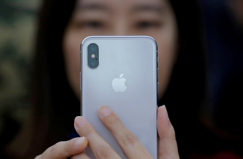 An attendee uses a new iPhone X during a presentation for the media in Beijing, China October 31, 2017. (photo credit: REUTERS/THOMAS PETER)