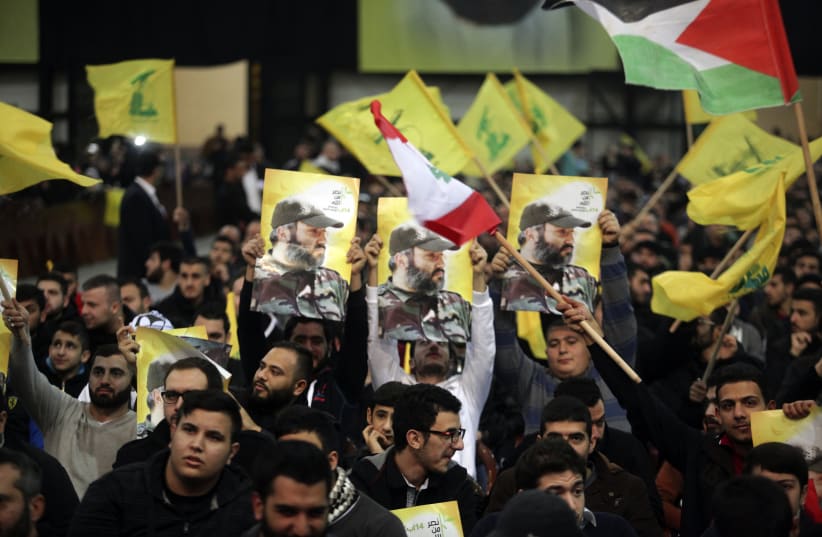 Supporters of Lebanon's Hezbollah leader Sayyed Hassan Nasrallah carry pictures of Hezbollah's late military leader Imad Moughniyah as Nasrallah appears on a screen to speak at an event to commemorate the deaths of six Hezbollah fighters and an Iranian general killed by an Israeli air strike in Syri (photo credit: REUTERS/KHALIL HASSAN)