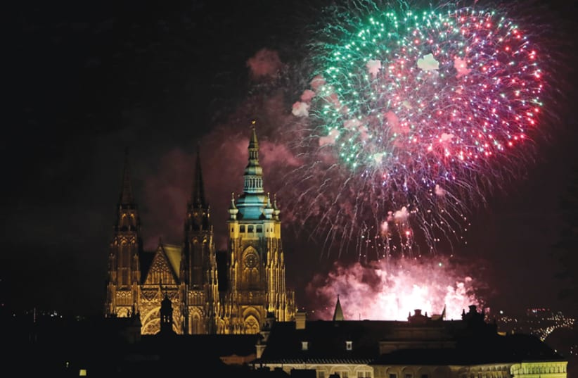 FIREWORKS EXPLODE in celebration of New Year’s Day on January 1, 2018, over the towers of the St. Vitus Cathedral at Prague Castle. (photo credit: REUTERS)