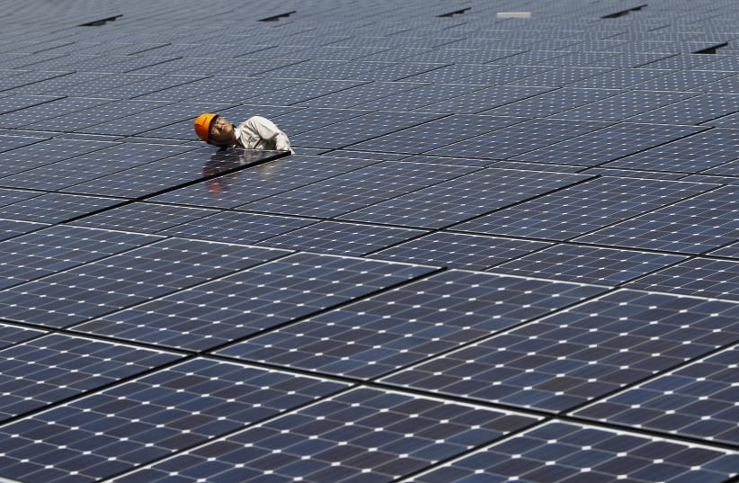A worker checks solar panels at a solar power field in Kawasaki, near Tokyo July 6, 2011 (photo credit: TORU HANAI / REUTERS)